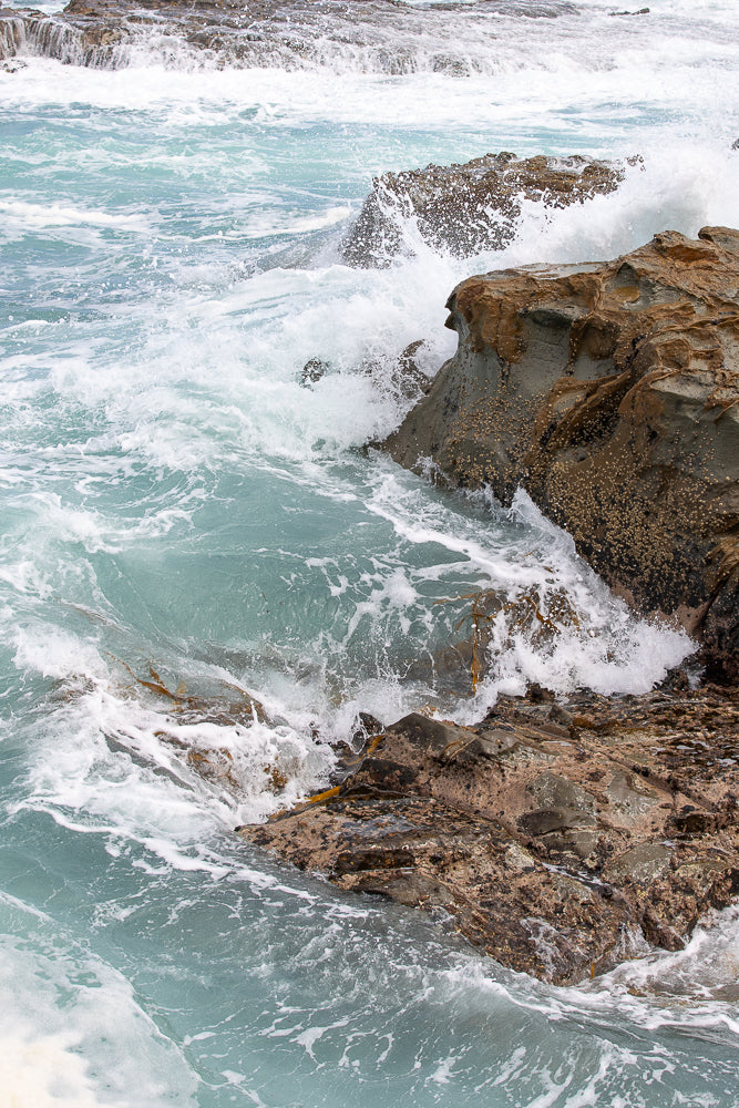 Waves crash against the rocky shore, creating a dynamic display of nature's power and beauty.