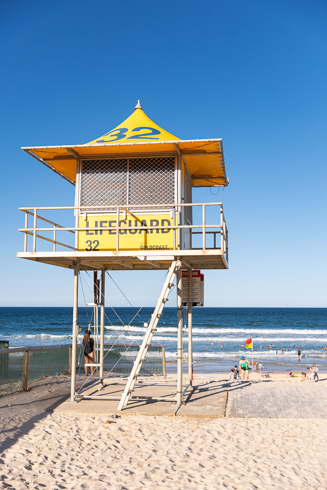 Iconic yellow lifeguard tower number 32 providing safety and surveillance on a sunny Gold Coast beach in Queensland Australia