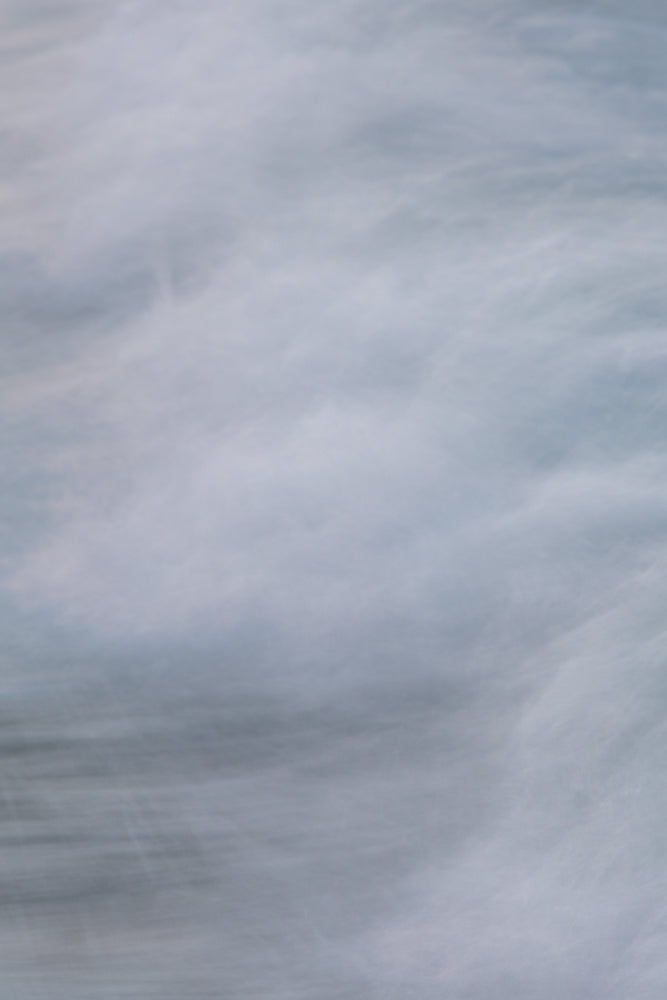 Abstract image of flowing water with soft, blurred white and blue tones, creating a sense of movement and tranquility.