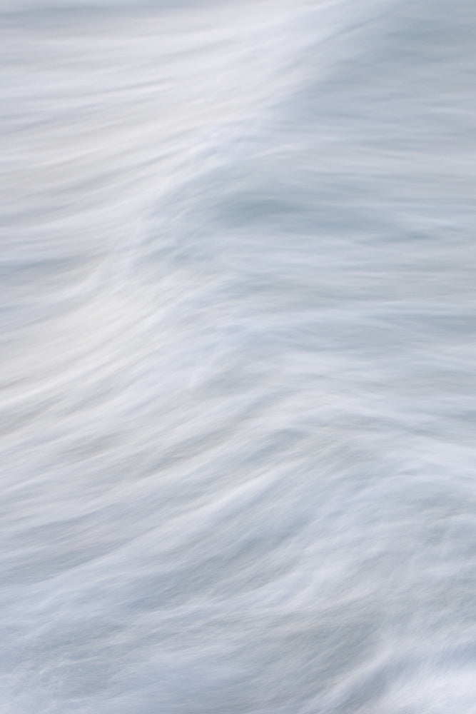 Abstract image of flowing water with soft, blurred white and blue lines creating a sense of movement and calm.