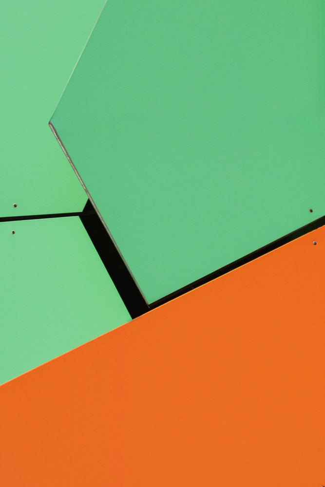 Abstract geometric pattern with large, flat planes of bright orange and orange. The shapes overlap.