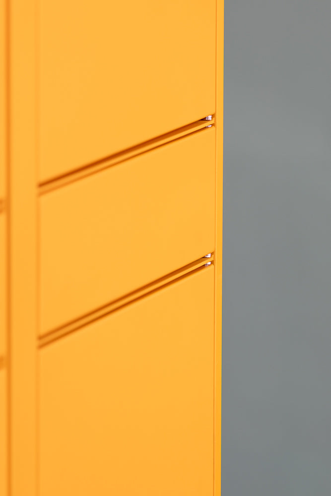 A close-up, abstract shot of a bright orange surface with horizontal indentations, possibly lockers, next to a muted gray surface.