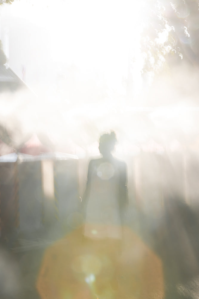 Woman silhouette walking into bright light with lens flares