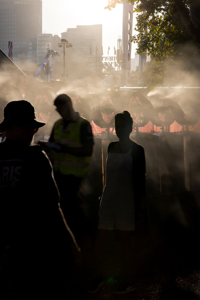People cooling off from mist fans in summer heat