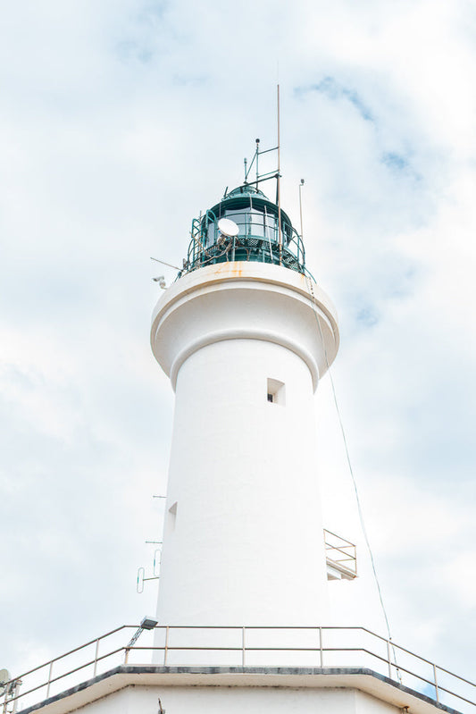 White lighthouse against a cloudy sky