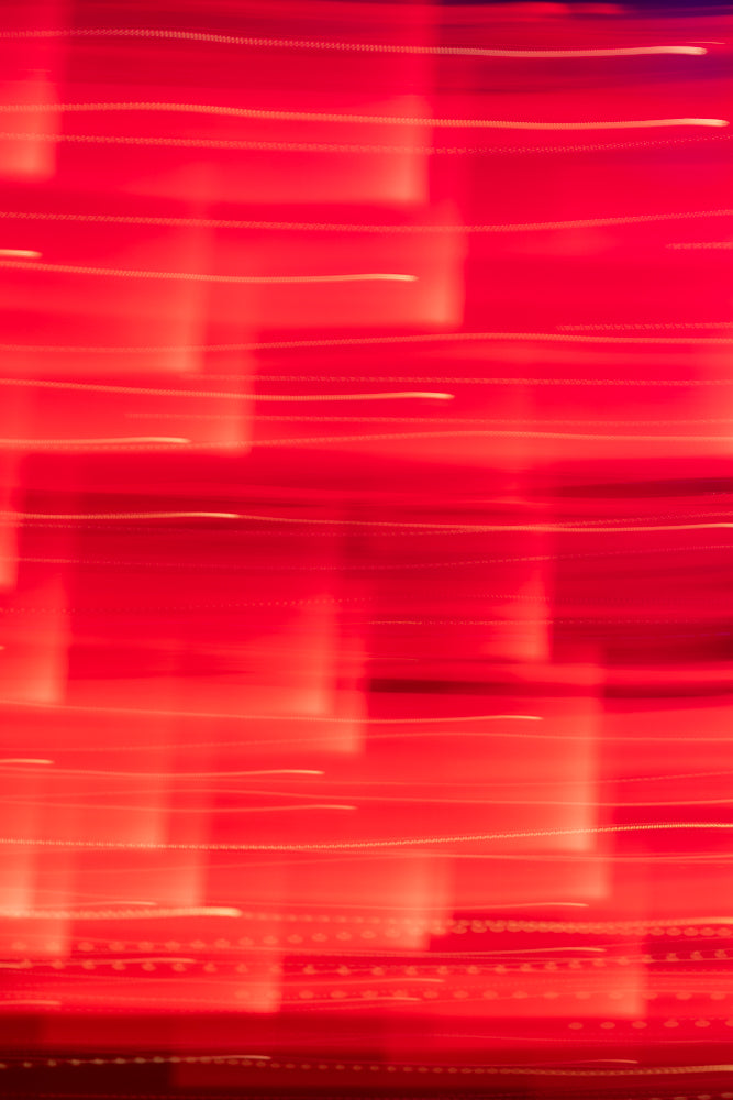 Abstract background of blurred red lights with horizontal streaks and dotted lines, suggesting motion or a digital interface.
