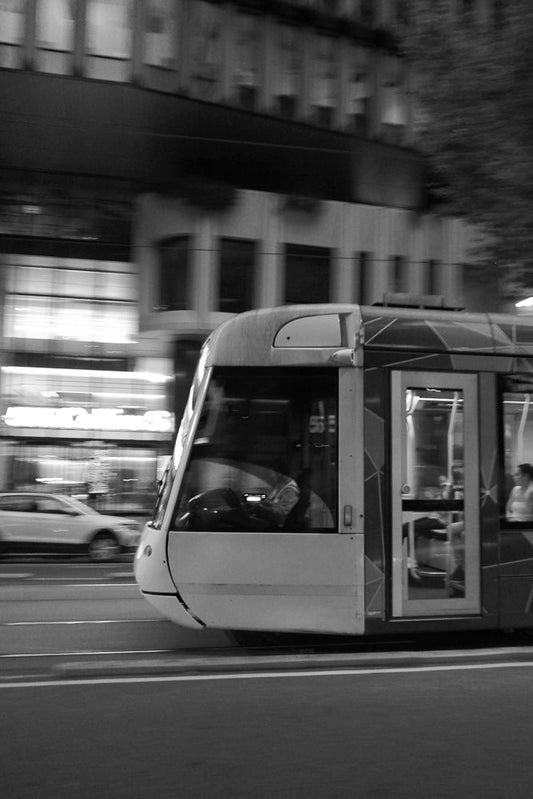 A tram in motion in Melbourne city in black and white