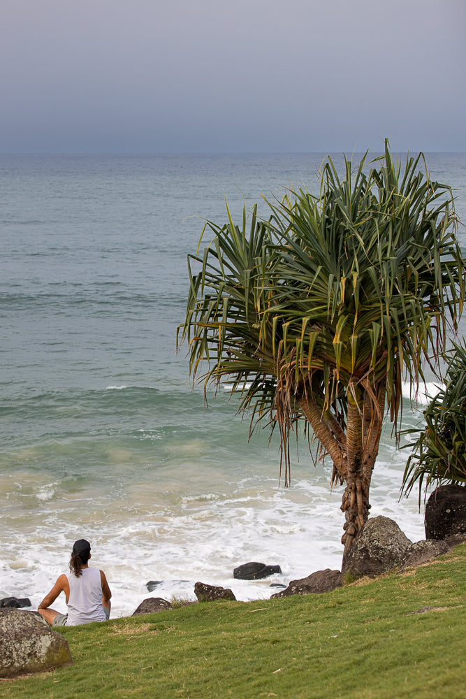 Serene coastal scene with a young man enjoying the tranquil view of the ocean waves at gold coast australia