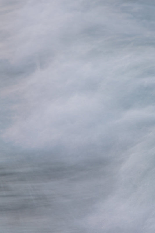 Abstract image of flowing water with soft, blurred white and blue tones, creating a sense of movement and tranquility.