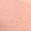 A close-up, abstract shot of wet sand with small bubbles and ripples, illuminated by soft, warm light, creating a serene and textured background.