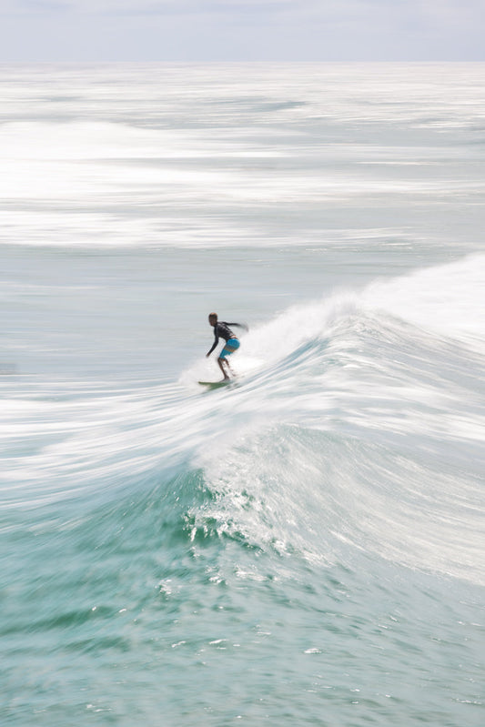 Motion blur ICU of Surfer riding turquoise ocean wave in summer