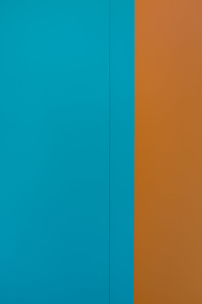 A solid, bright teal blue and orange background