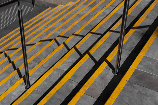 Urban staircase with yellow safety lines and shadows