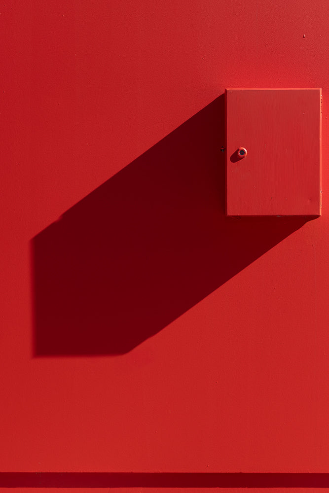 Red wall creating minimalism with shadow and box