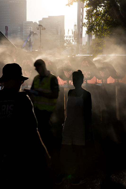 People cooling off from mist fans in summer heat