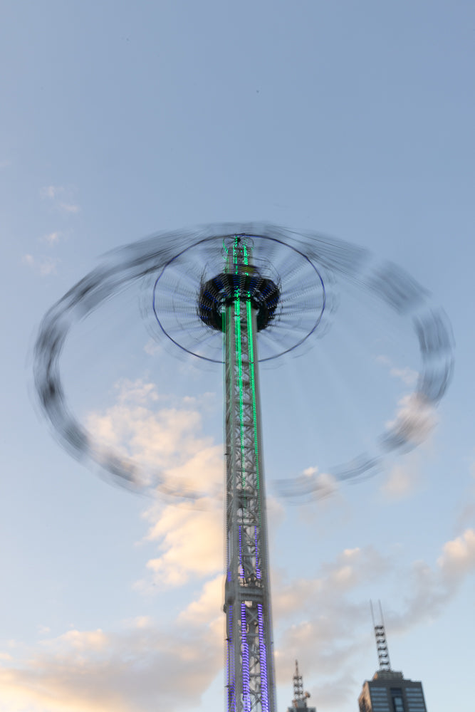 Amusement ride spinning with motion blur at evening carnival