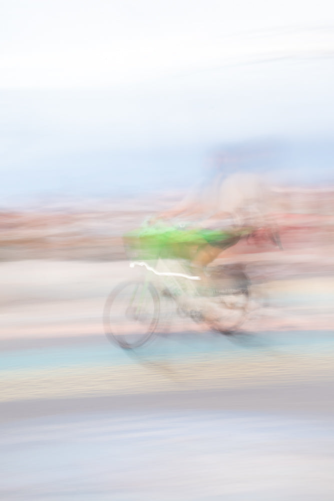 Cyclist moving fast with dreamy pastel motion blur