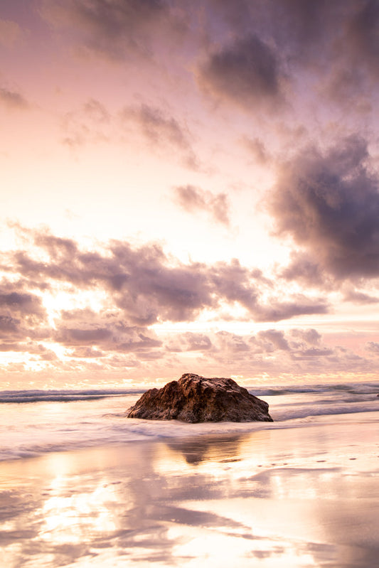 Rock formation on a tranquil beach during a dramatic pink sunrise at Miami Beach, Gold Coast