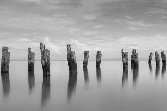 Black and White dilapidated pier with smooth water at Clifton Springs Bay