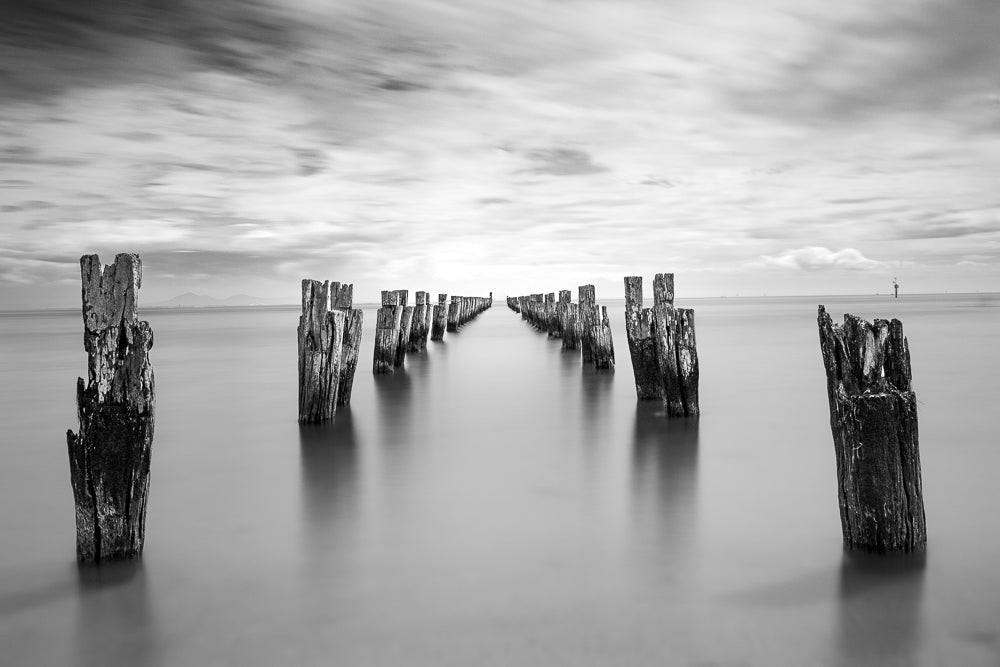 Black and White old pier pylons with long exposure smooth water at Clifton Springs Bay, bellarine Peninsular, Victoria