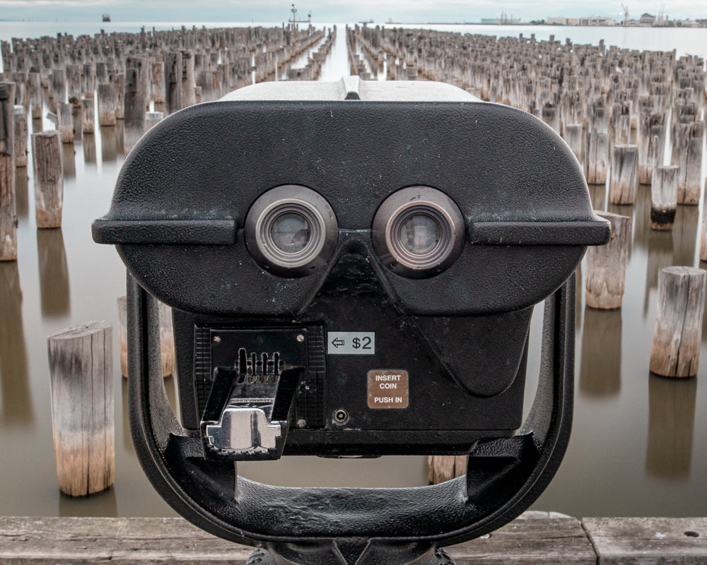 Public telescope at Princes Pier in Port Melbourne with wooden piles