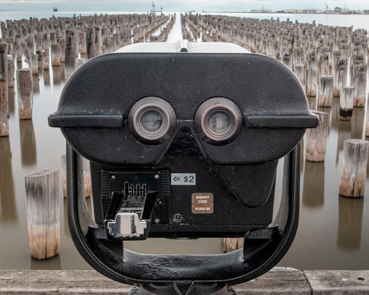 Public telescope at Princes Pier in Port Melbourne with wooden piles