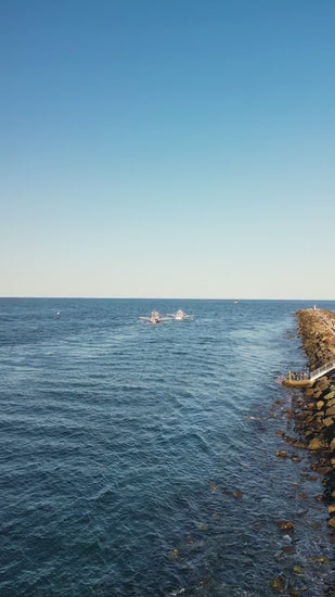 Fishing trawlers near a rock wall in the ocean