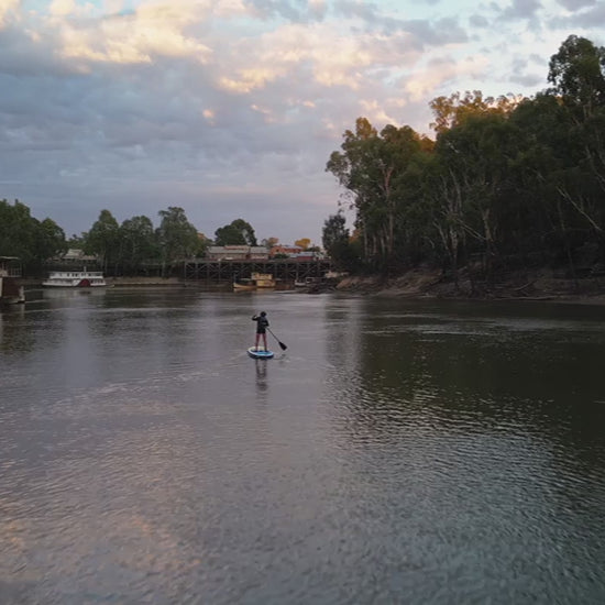 Beautiful drone shot across Murray River from Paddleboarder to Echuca Discover Centre at Sunset. High quality 4k footage