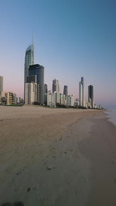 Vertical fly over beach with Gold Coast skyline