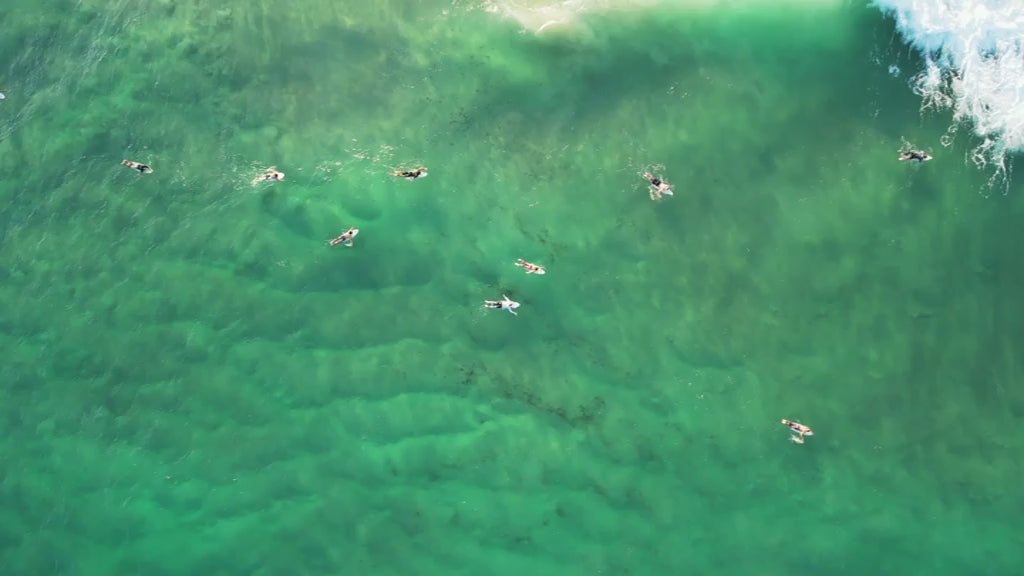 Top-down aerial view of surfers waiting for waves on the Gold Coast